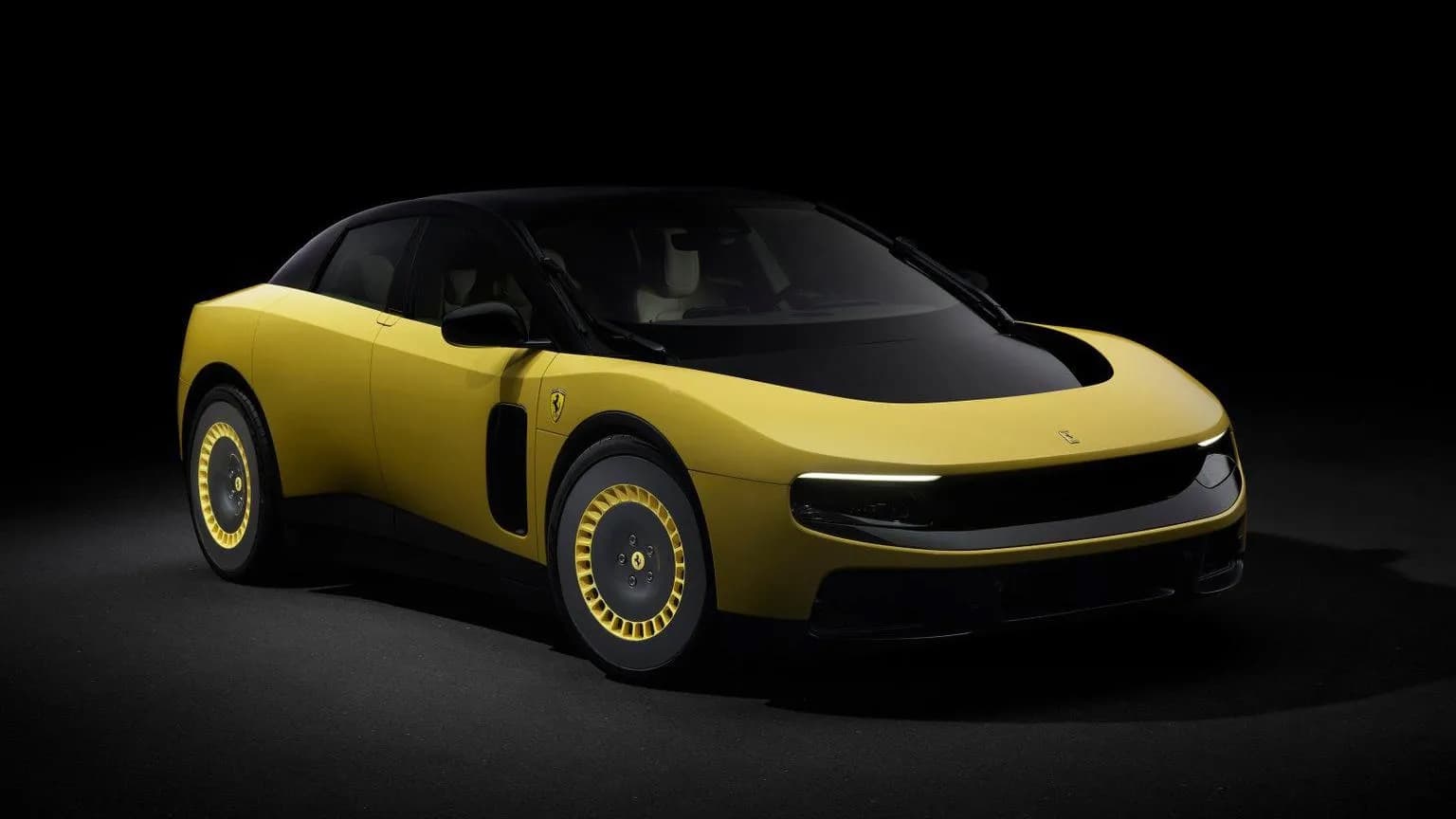 Ferrari's first fully electric car, a yellow four door, shown against a black studio backdrop