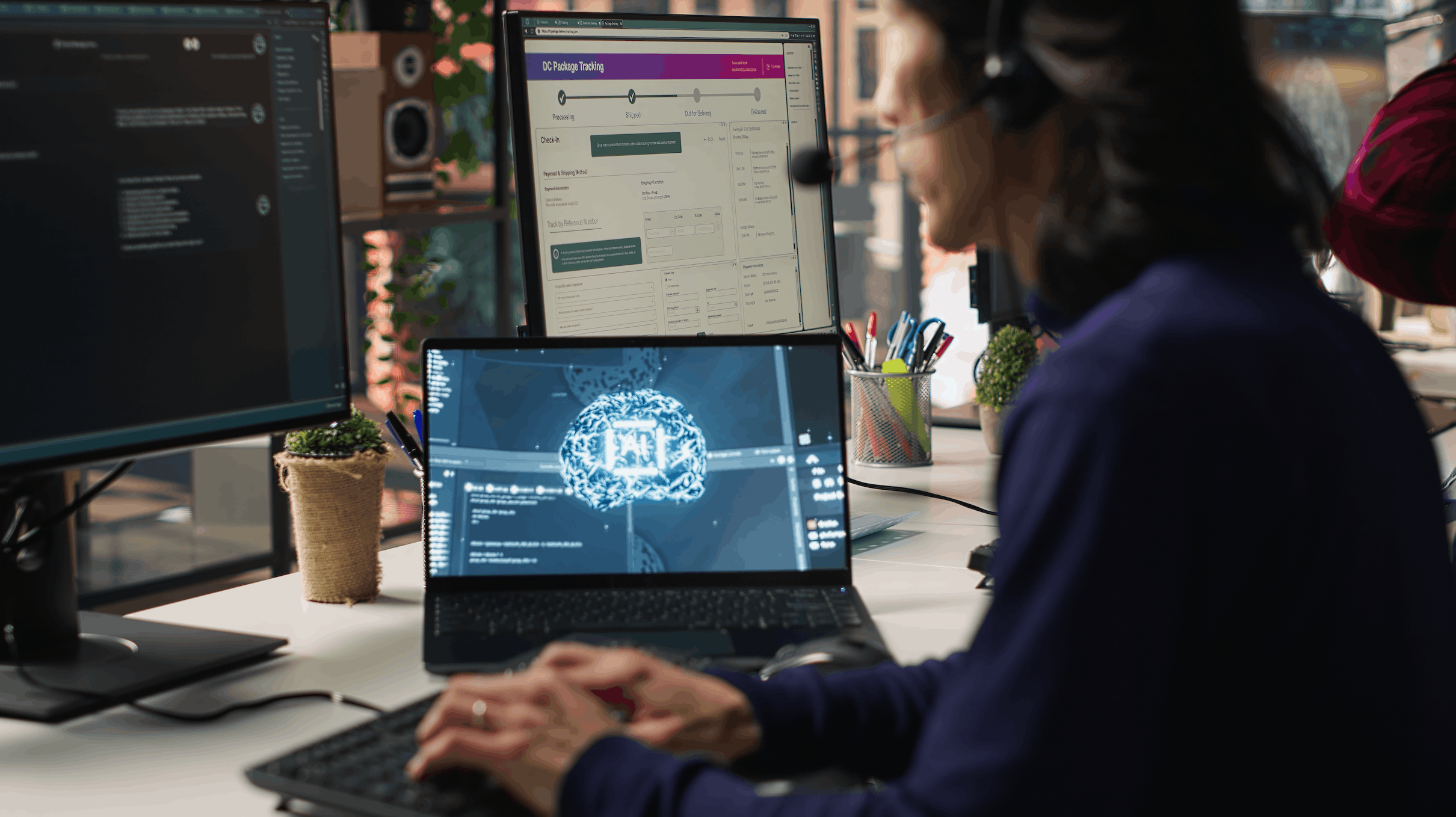 A person at a desk working on a laptop showing a glowing AI brain graphic with a package tracking screen above