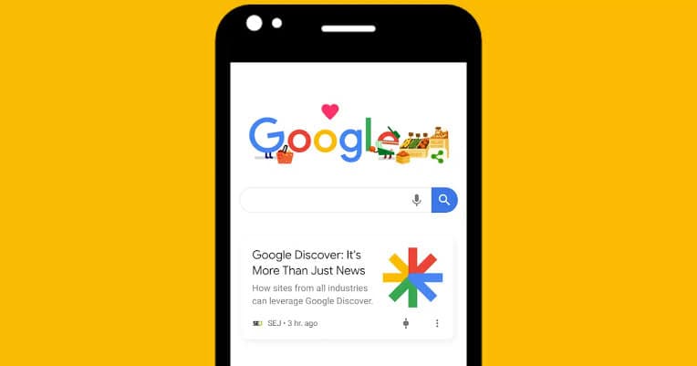 A smartphone on a yellow background showing the Google search page and a Google Discover card below the search bar