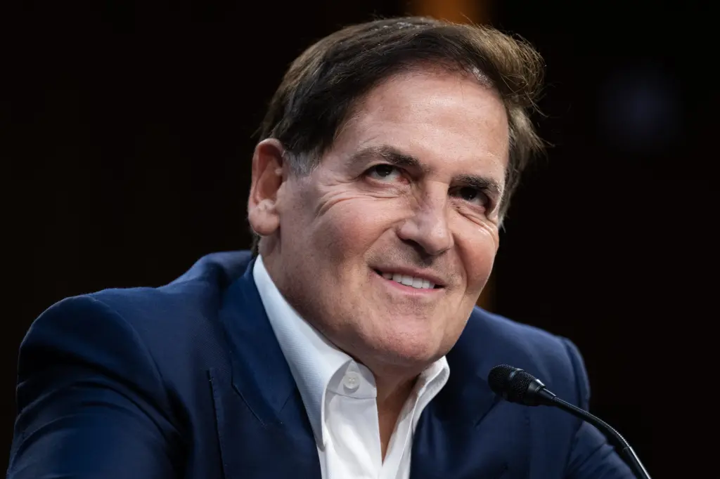 Mark Cuban smiling while speaking at a microphone