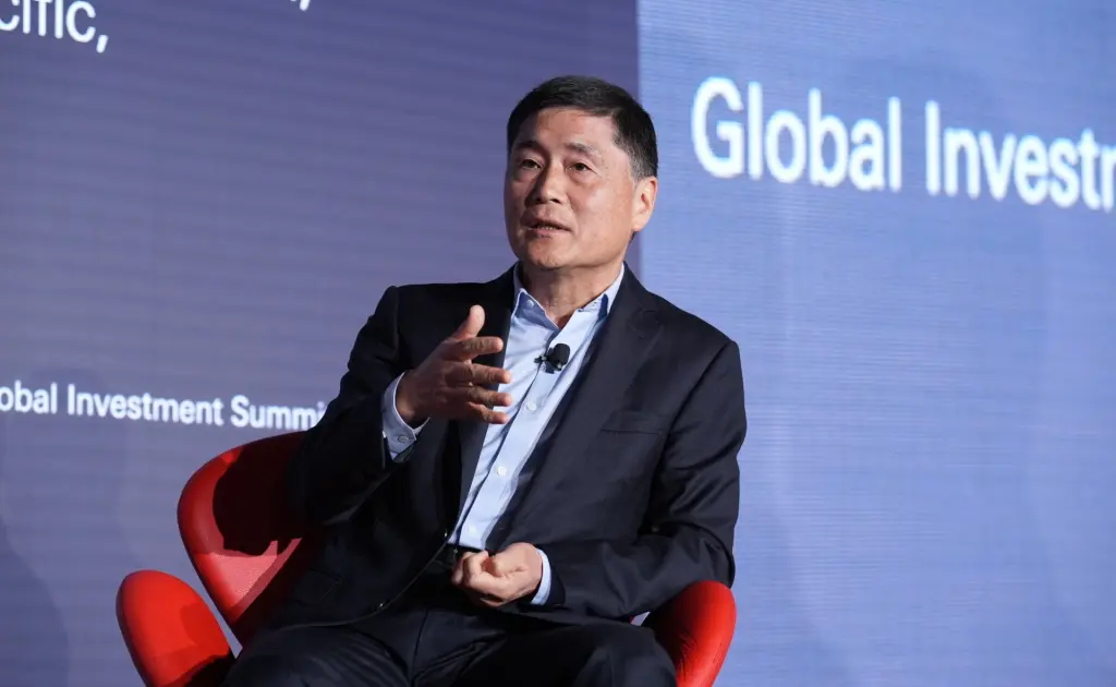 Ming Lu gesturing while speaking on stage at the Global Investment Summit